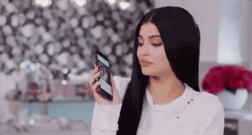 Kylie Jenner kissing her cell phone.
