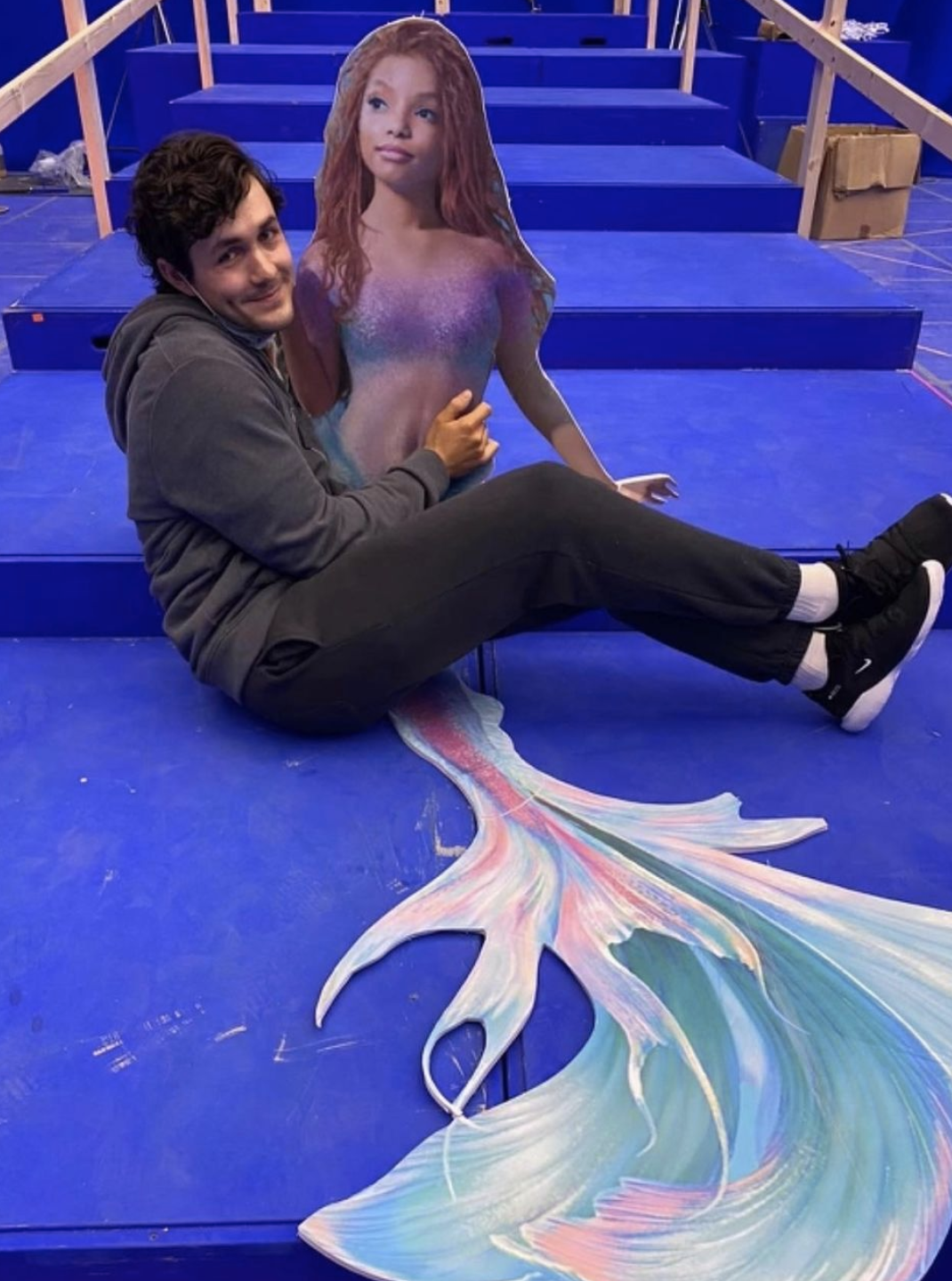 Jonah sitting with a cutout of Halle as Ariel
