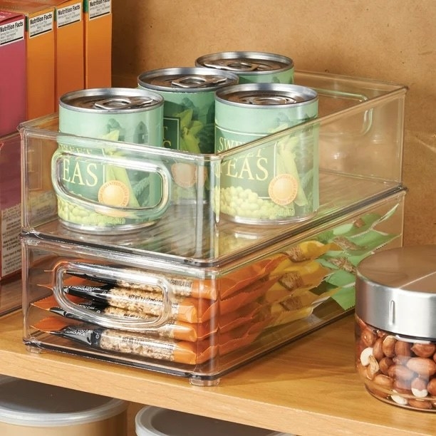 Clear bins used in a pantry to hold various snacks and cans