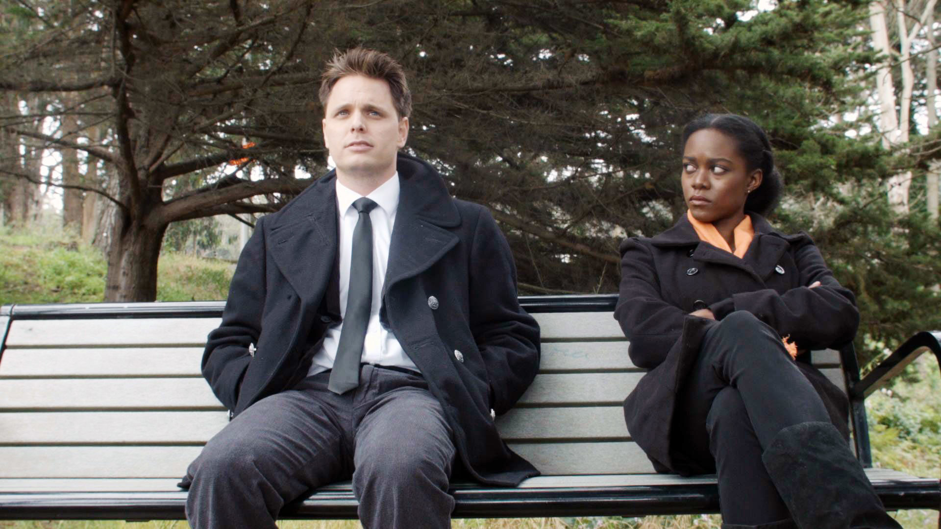 A woman looking angrily at a man sitting next to her on a bench