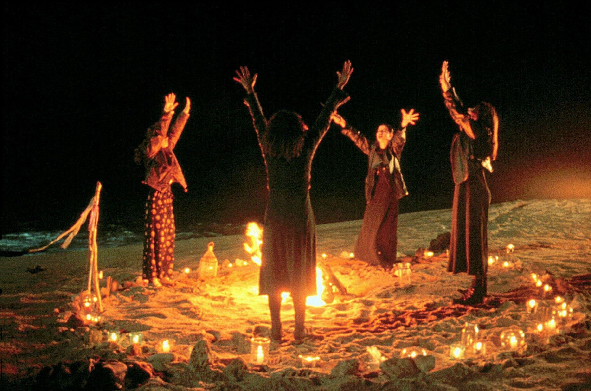 Four young women attempt to conjure magic on a beach
