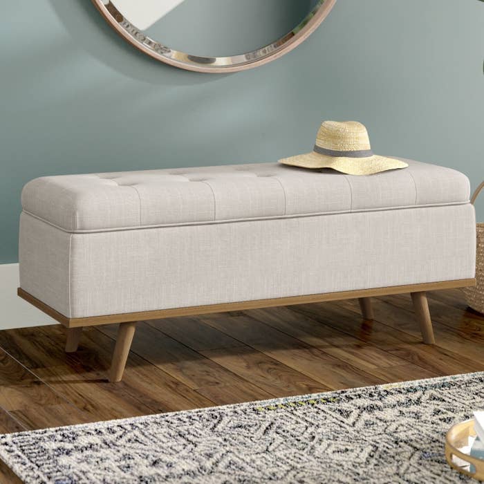 The bench styled in a room with a hat on top