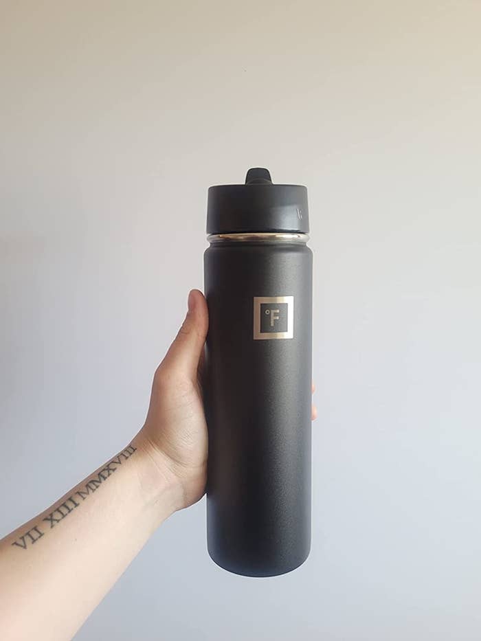 a reviewer holding their bottle in black