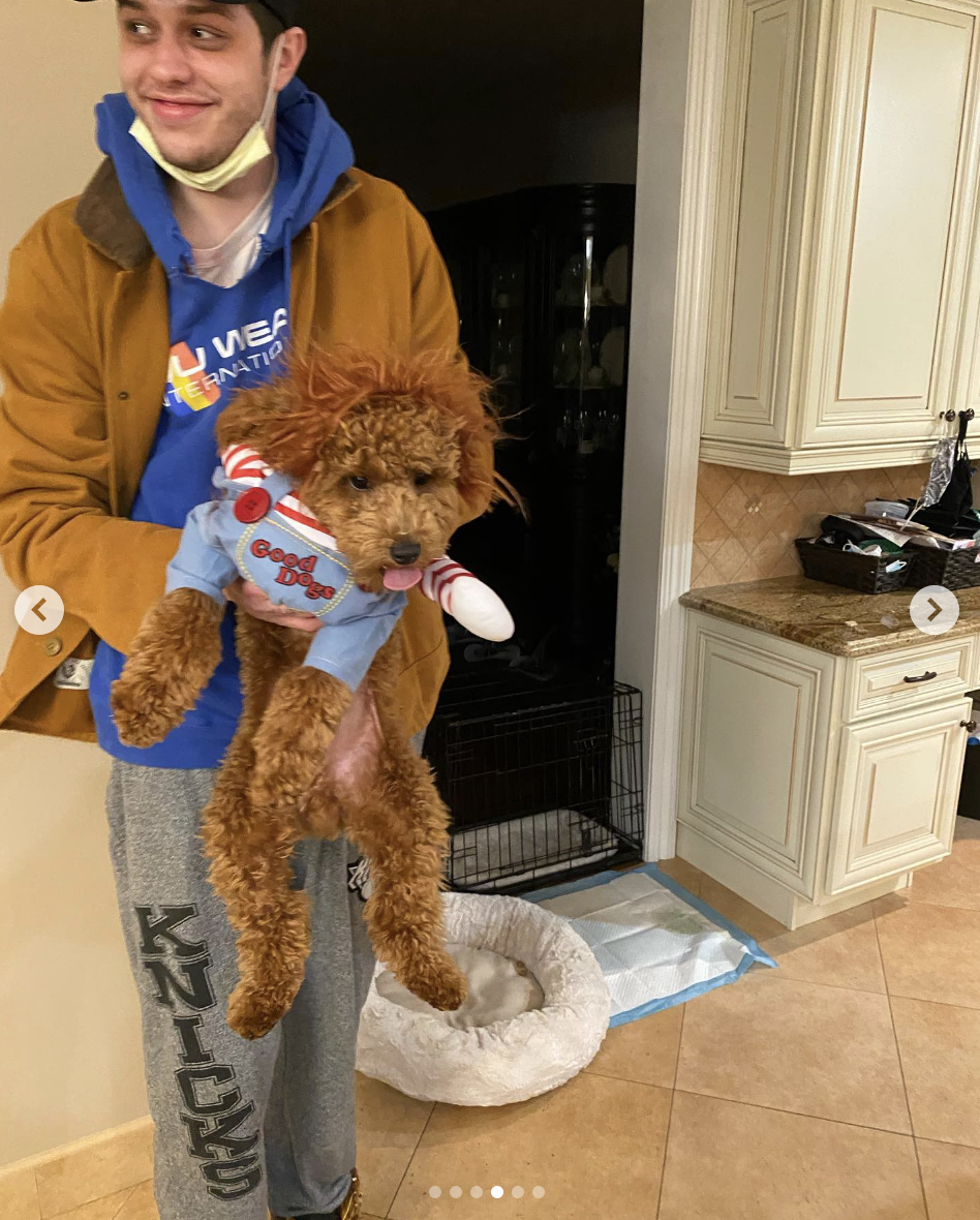 Pete holding up Henry, who&#x27;s wearing an outfit that says &quot;Good Dogs&quot;