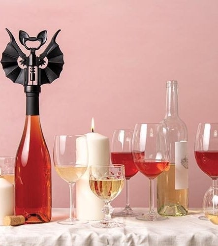 a bottle of wine with the bat-shaped wine opener in it
