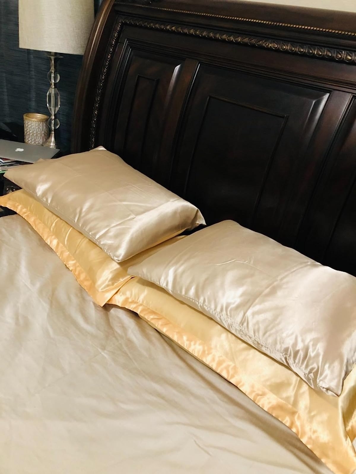 reviewer image of four pillows in satin pillowcases on a bed