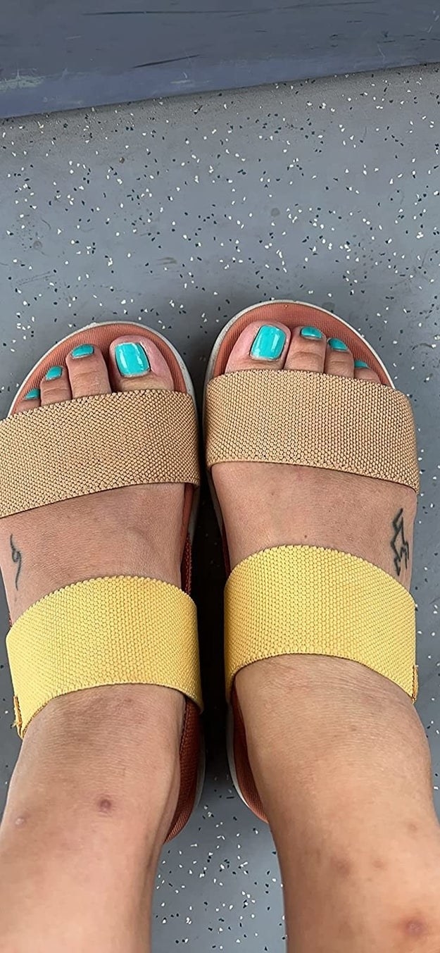 A reviewer wearing yellow and brown sandals