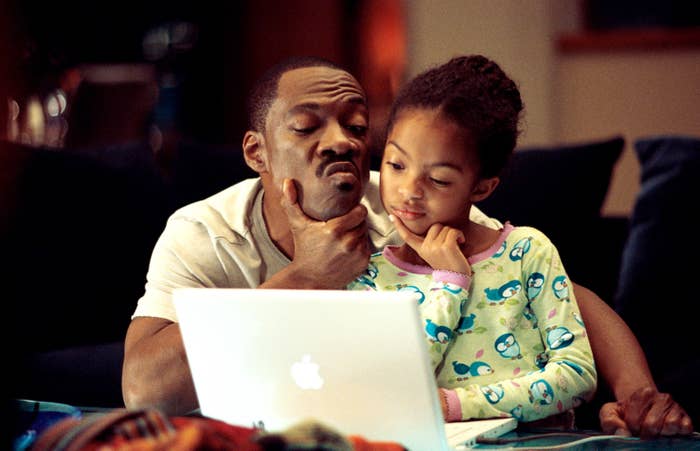 Eddie Murphy and Yara Shahidi, when she was a child, contemplate something on a laptop in a scene from the film Imagine That