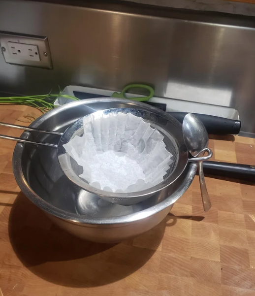 Someone using a spoon with a strainer