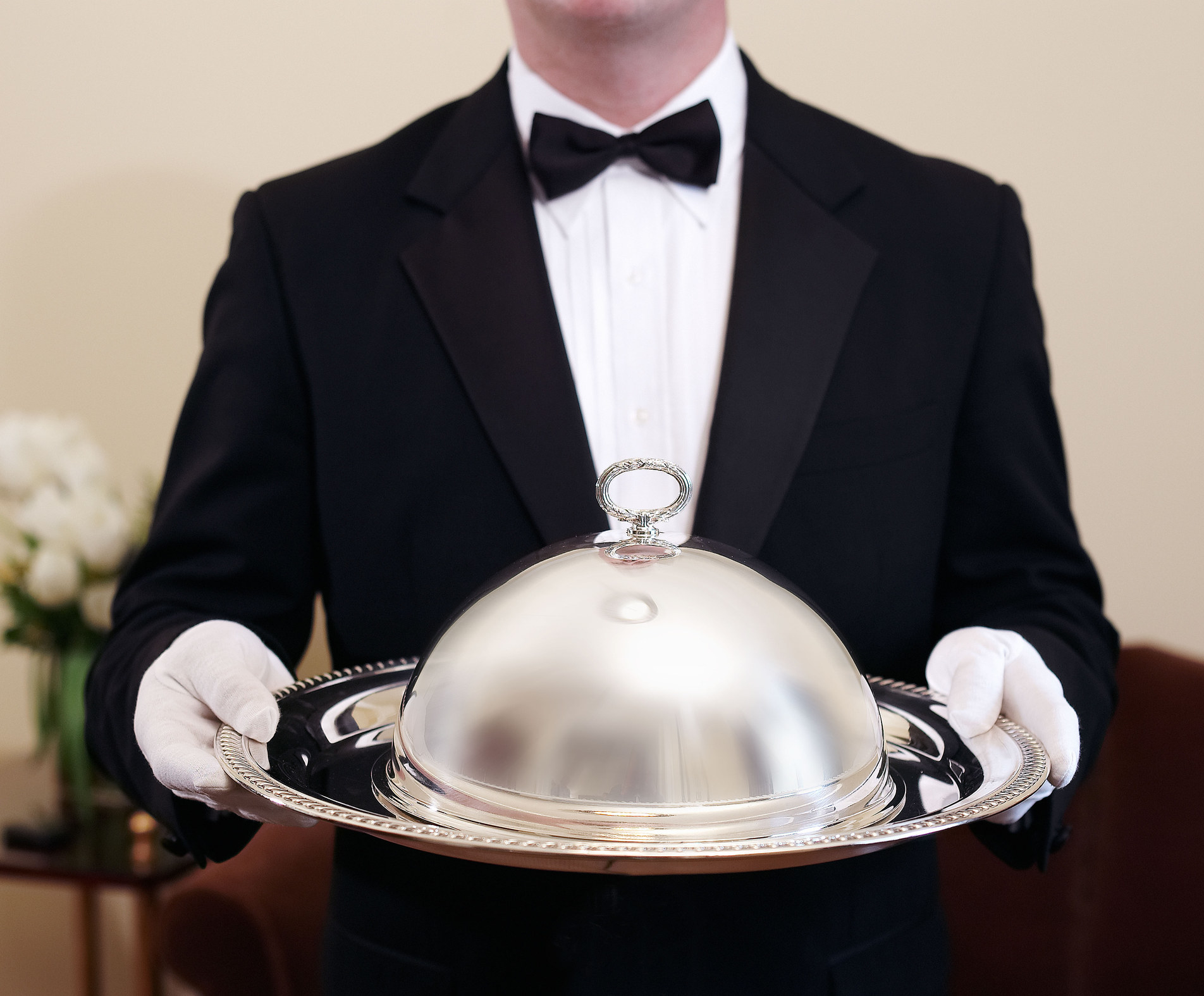 A butler holding a covered tray