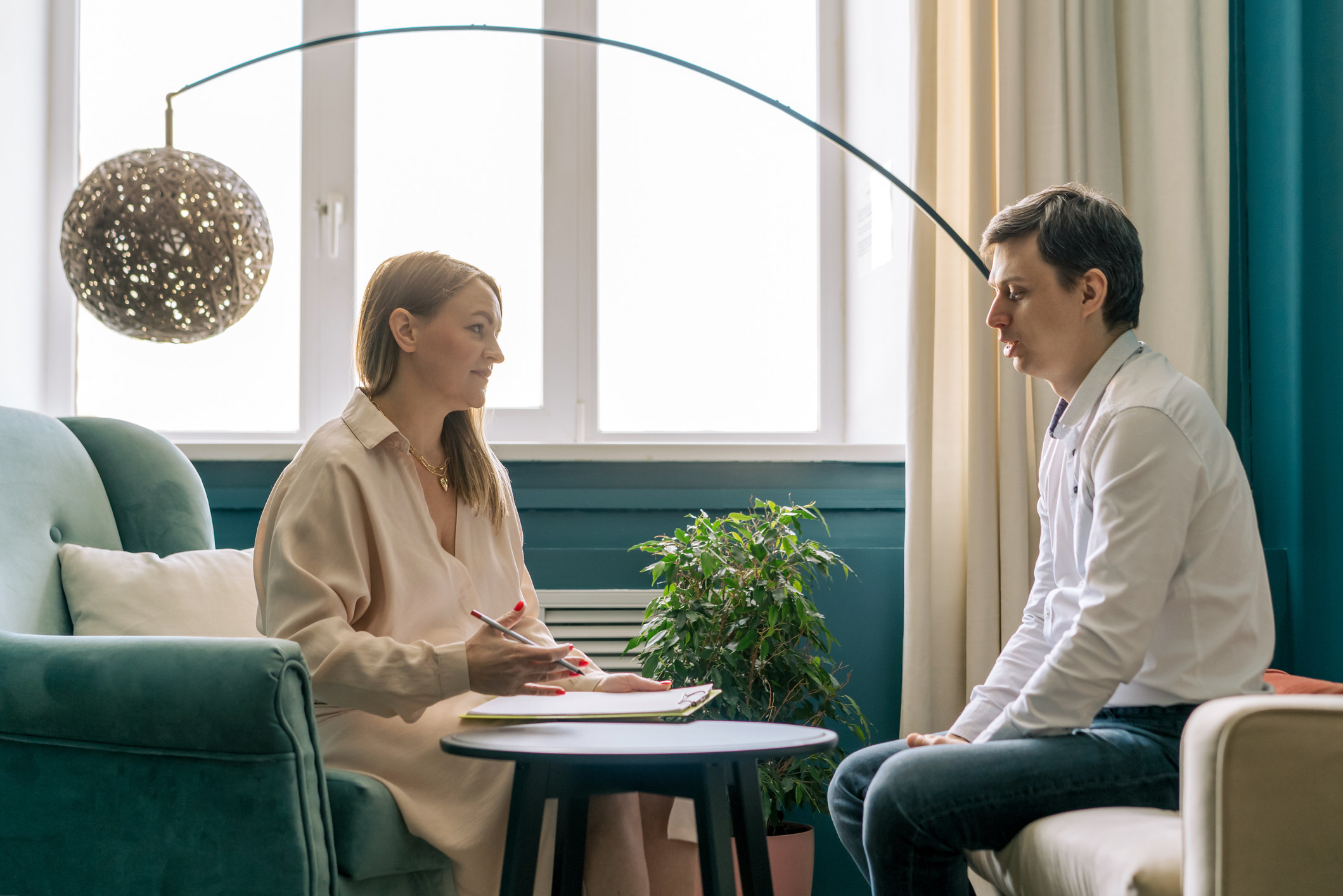 Psychologist or therapist talking to a patient seated