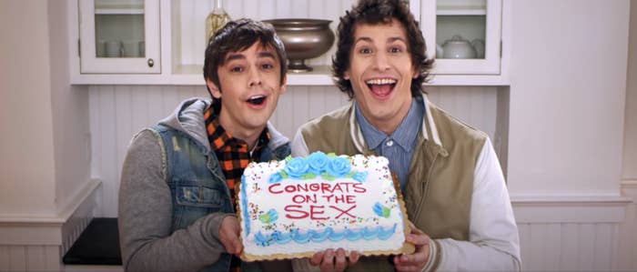 Two guys holding a cake that says "Congrats on the SEX"