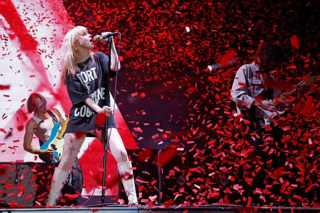 Paramore performing on stage as confetti flies around them