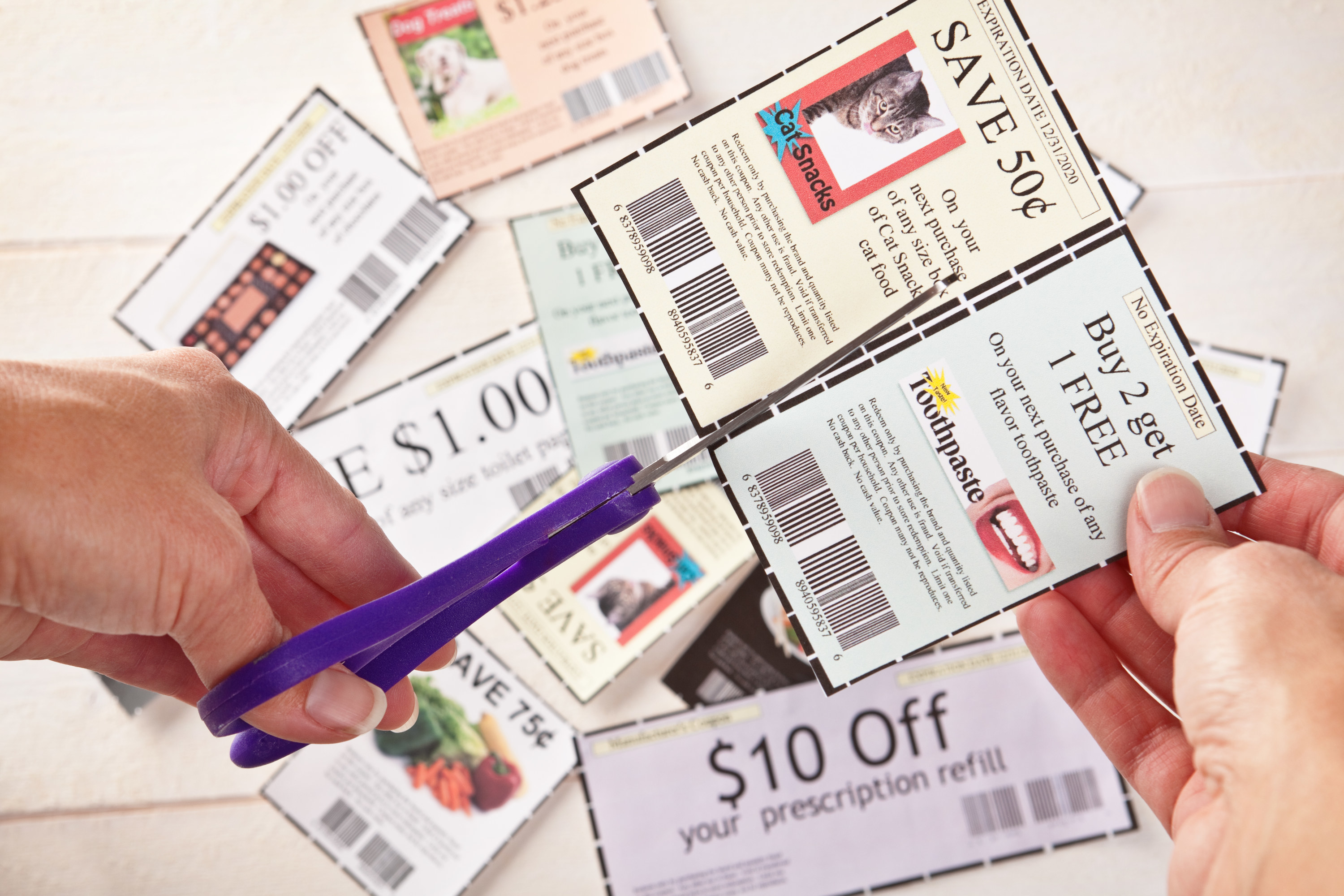 person cutting out coupons
