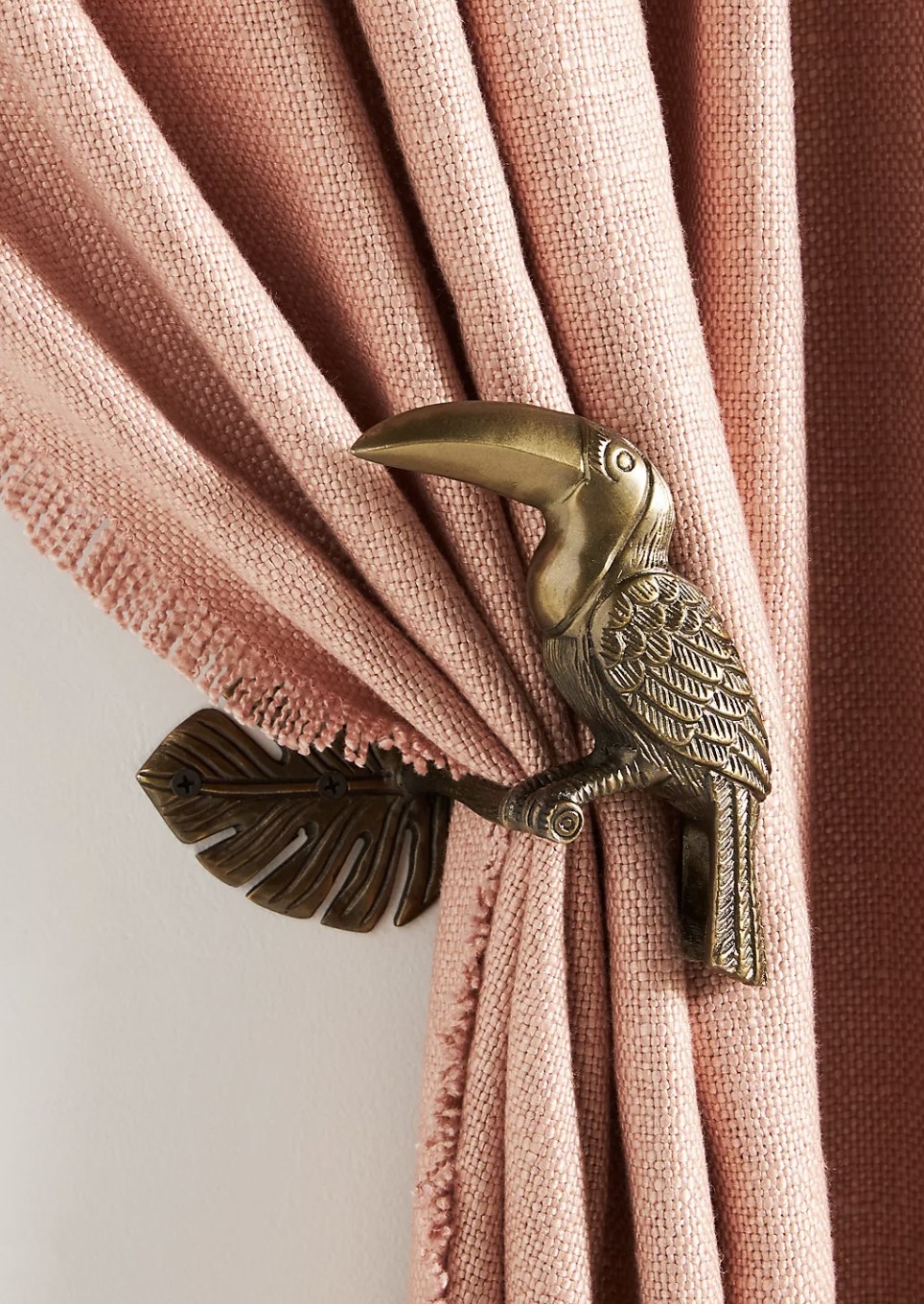 The toucan tying back pink curtains