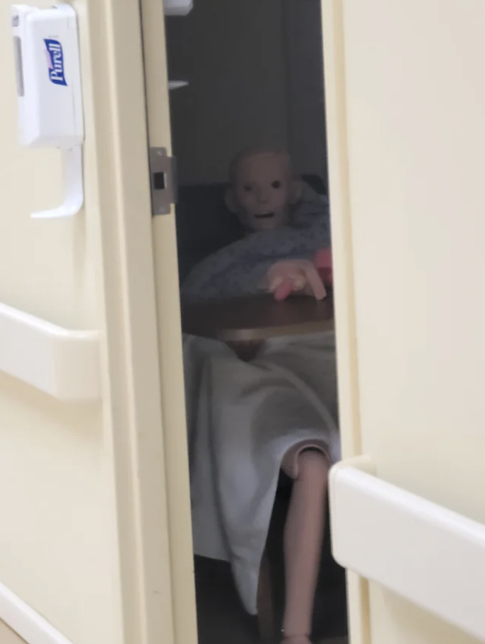 A doll sitting in a dark closet