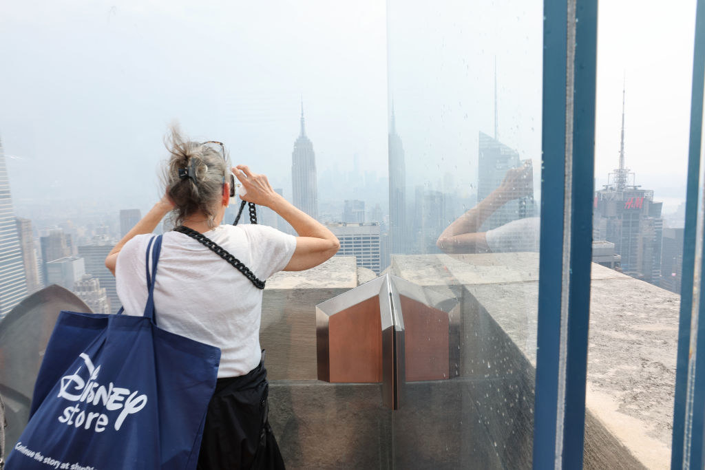 人在曼哈顿的摩天大楼上,笼罩在浓密的烟雾