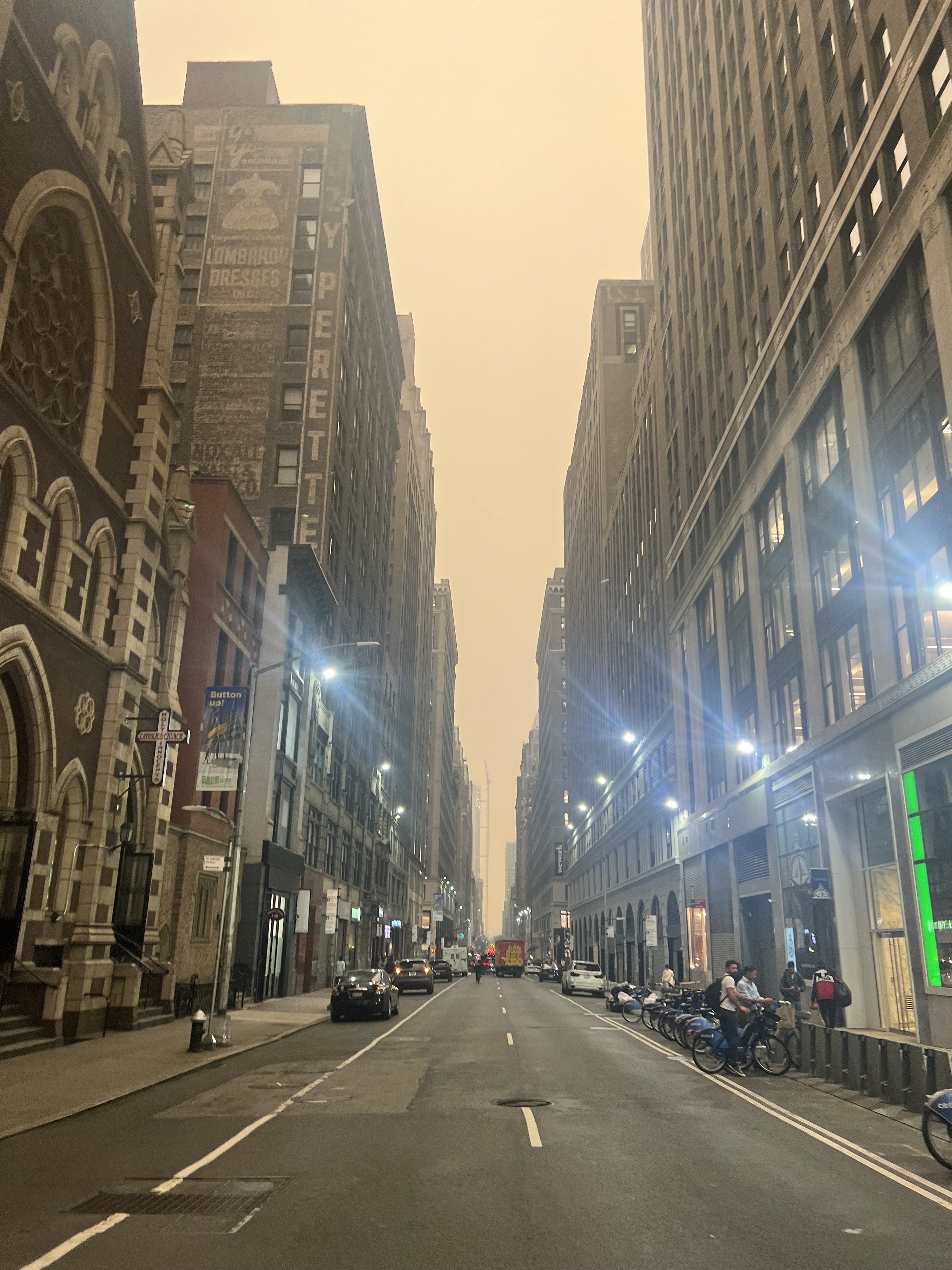 Several people on a Manhattan street with the foggy sky in the background