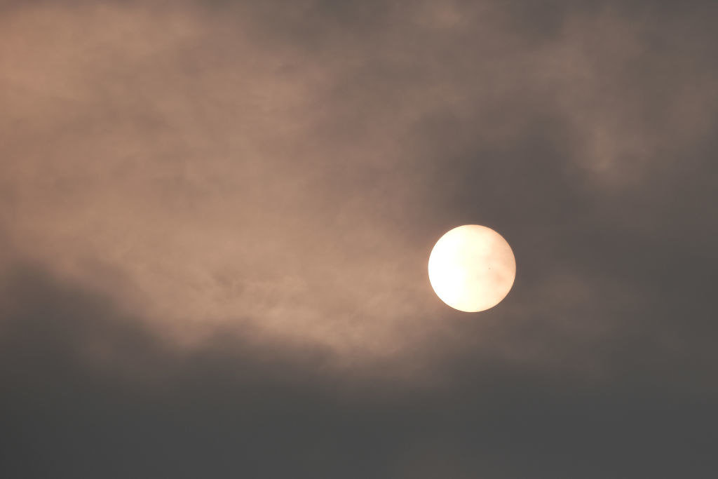 The sun over New York City takes on a red appearance on a hazy morning