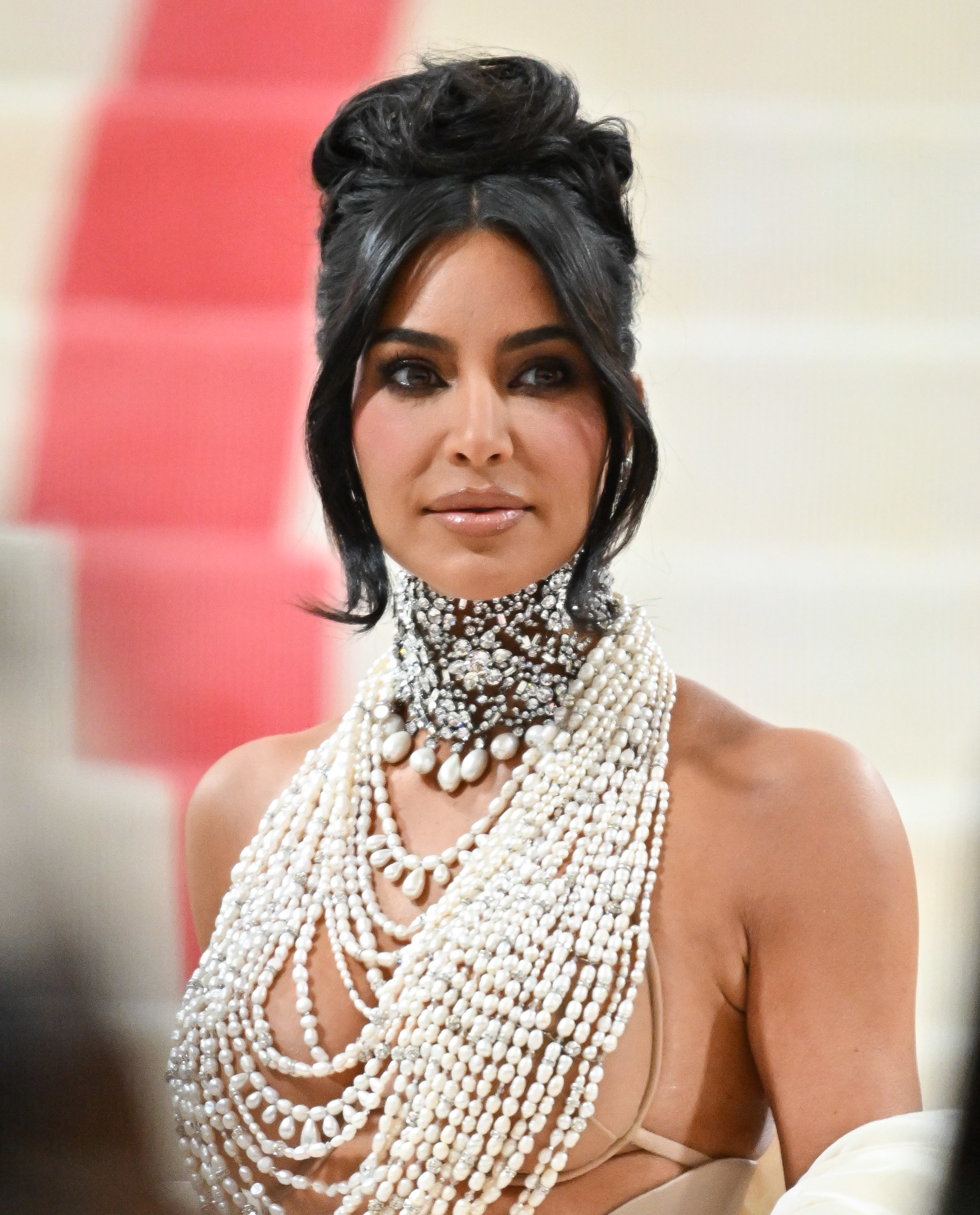 Close-up of Kim wearing an elaborate, multistrand pearl necklace