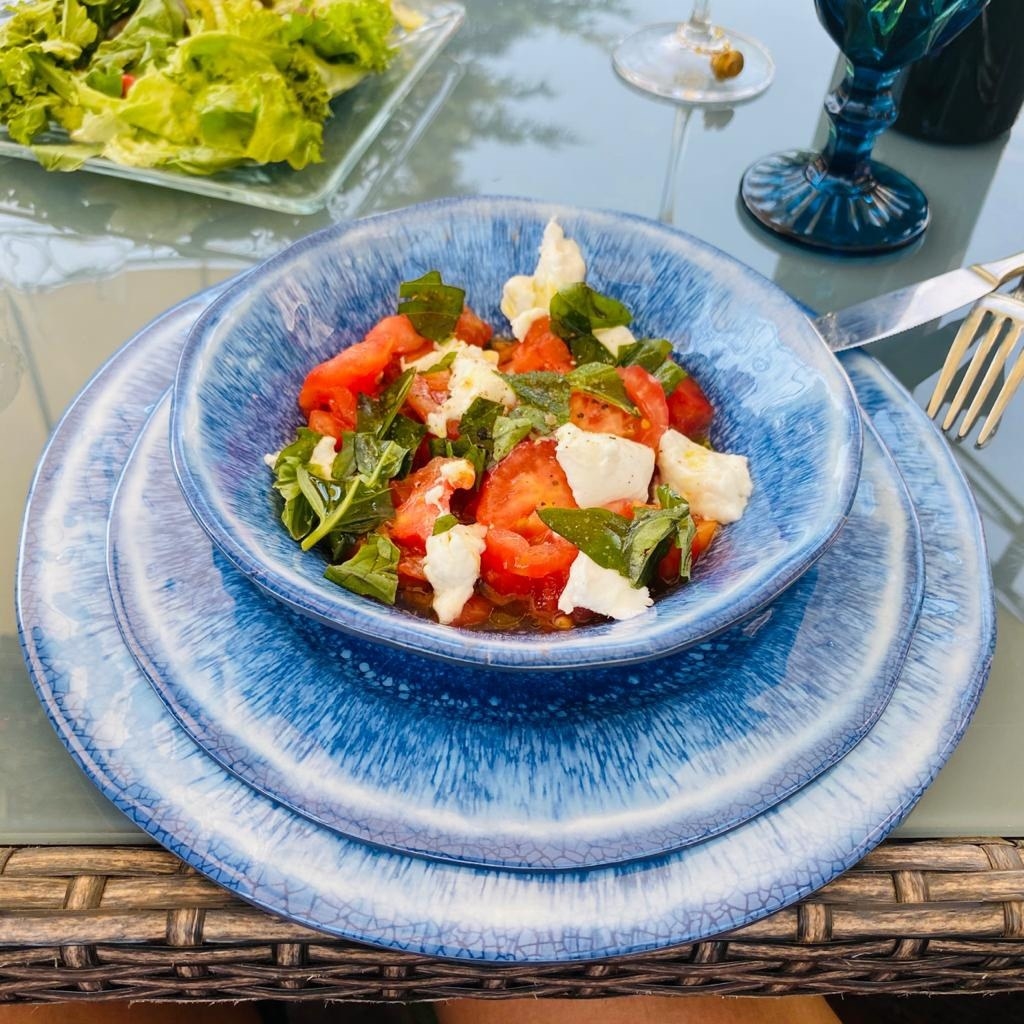 Reviewer image of a salad in the blue bowl with blue plates underneath it
