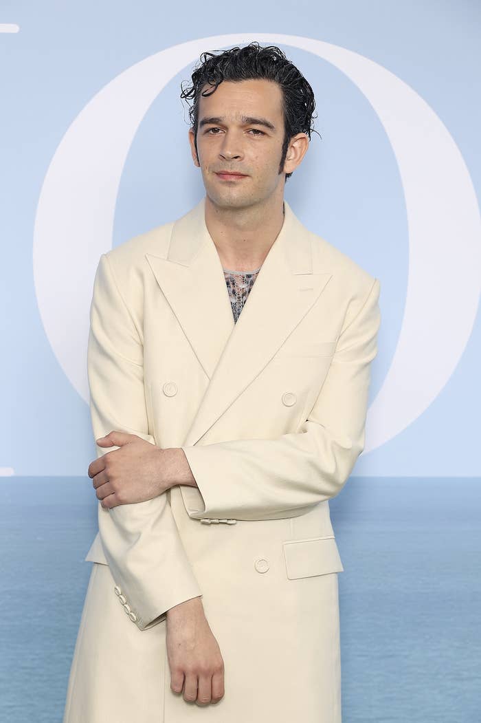 Matt Healy wears a suit as he stands for a picture at a red carpet event