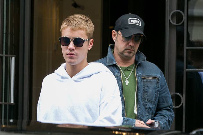 Justin&#x27;s dad walks behind him as they exit a building