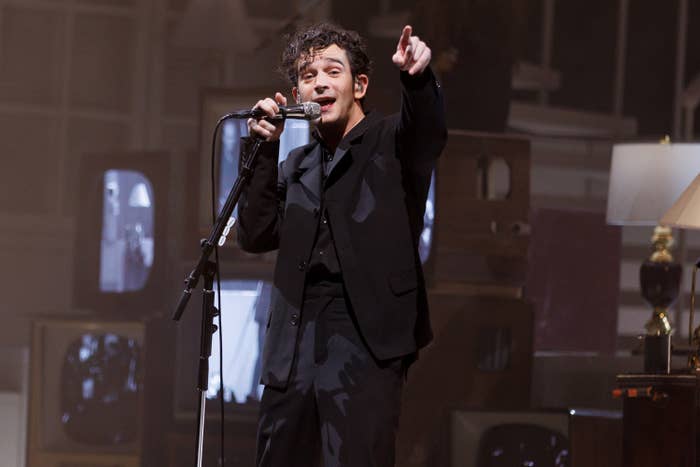 Matt Healy singing onstage as he points to the crowd