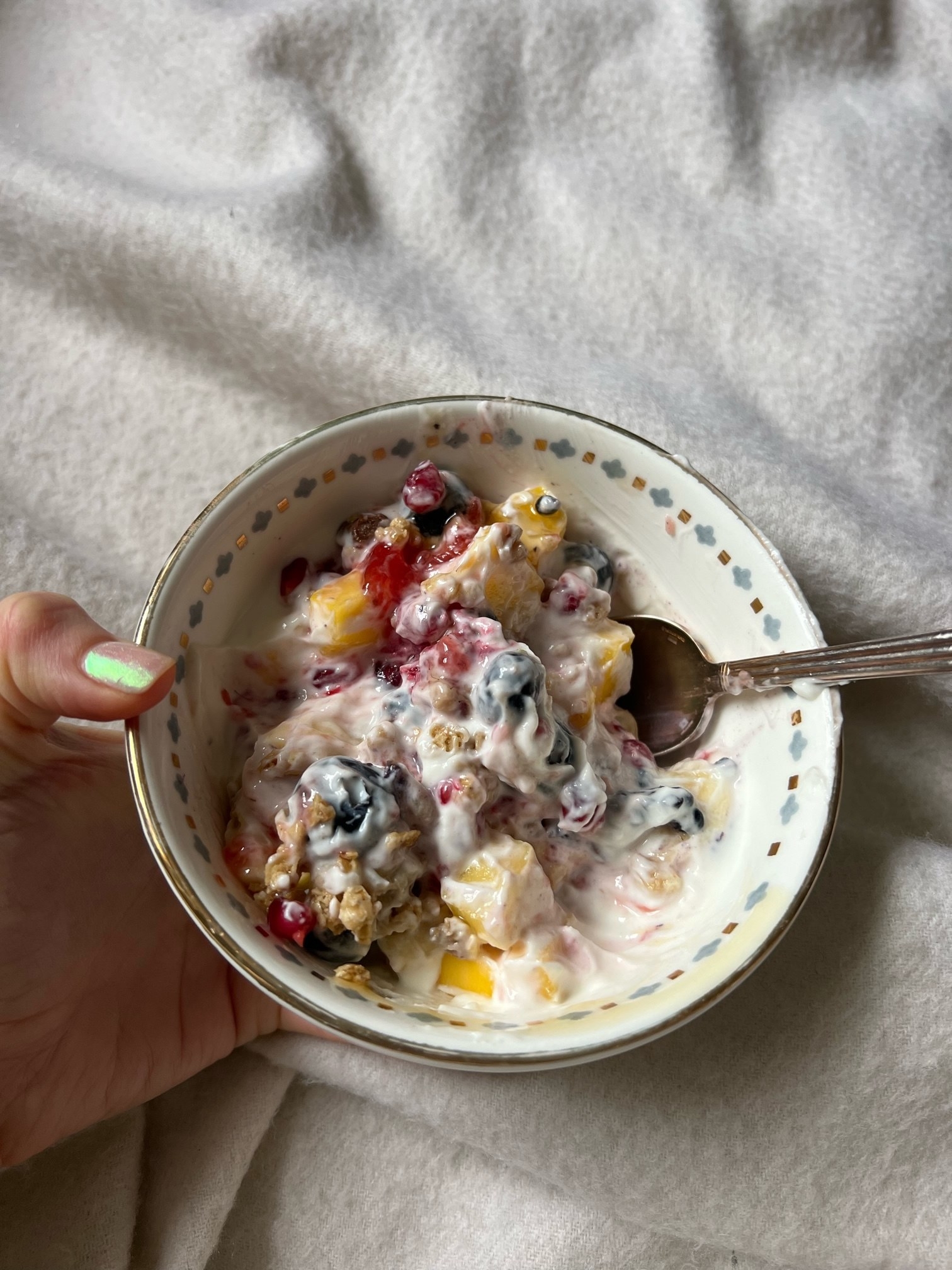 A bowl of fruit and yogurt and granola.
