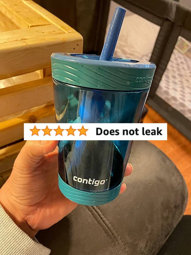 A reviewer holding the cup with a lid and straw with a 5-star review that says 