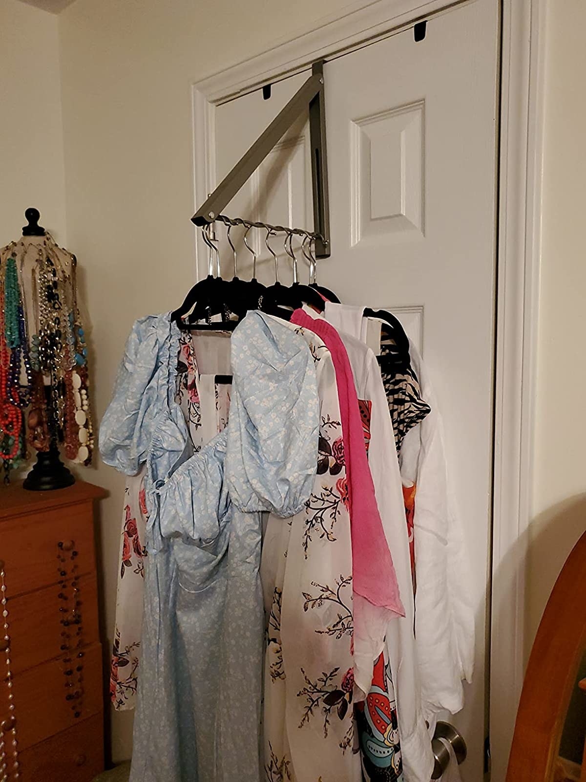 a reviewer photo of the rack with clothes hanging on it