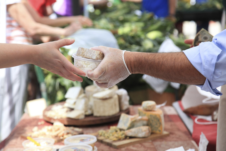 Someone handing someone else fancy cheese