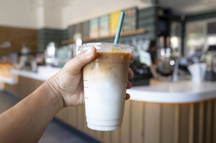 Someone holding up a coffee drink