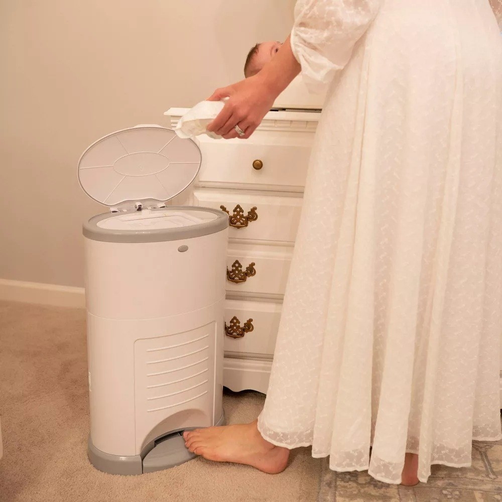 model opening the diaper pail with their foot