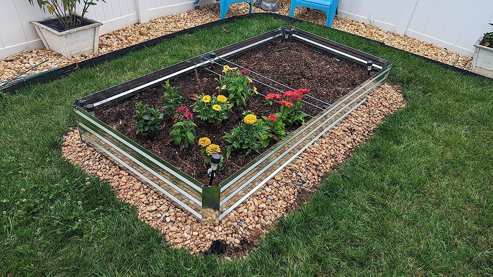 Reviewer&#x27;s photo of the raised garden bed with colorful flowers planted in it