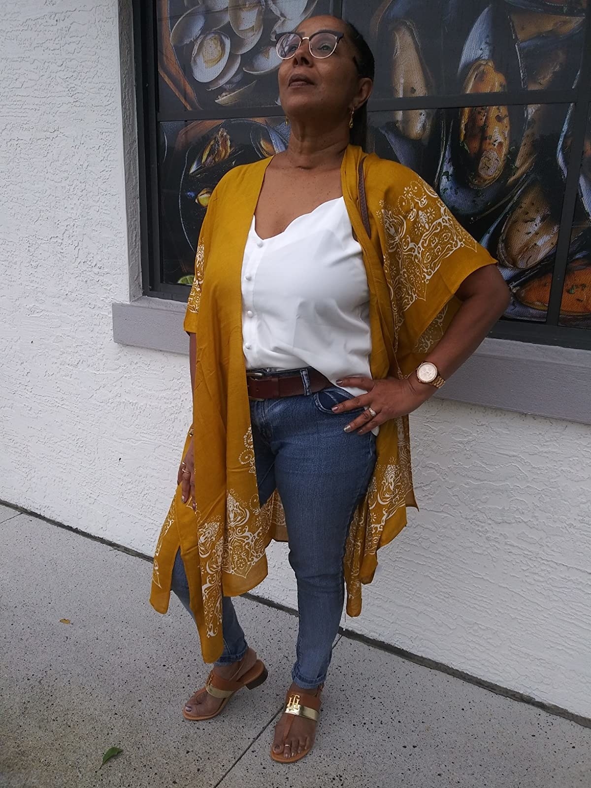 Reviewer wearing mustard yellow and white patterned kimono over white shirt and jeans