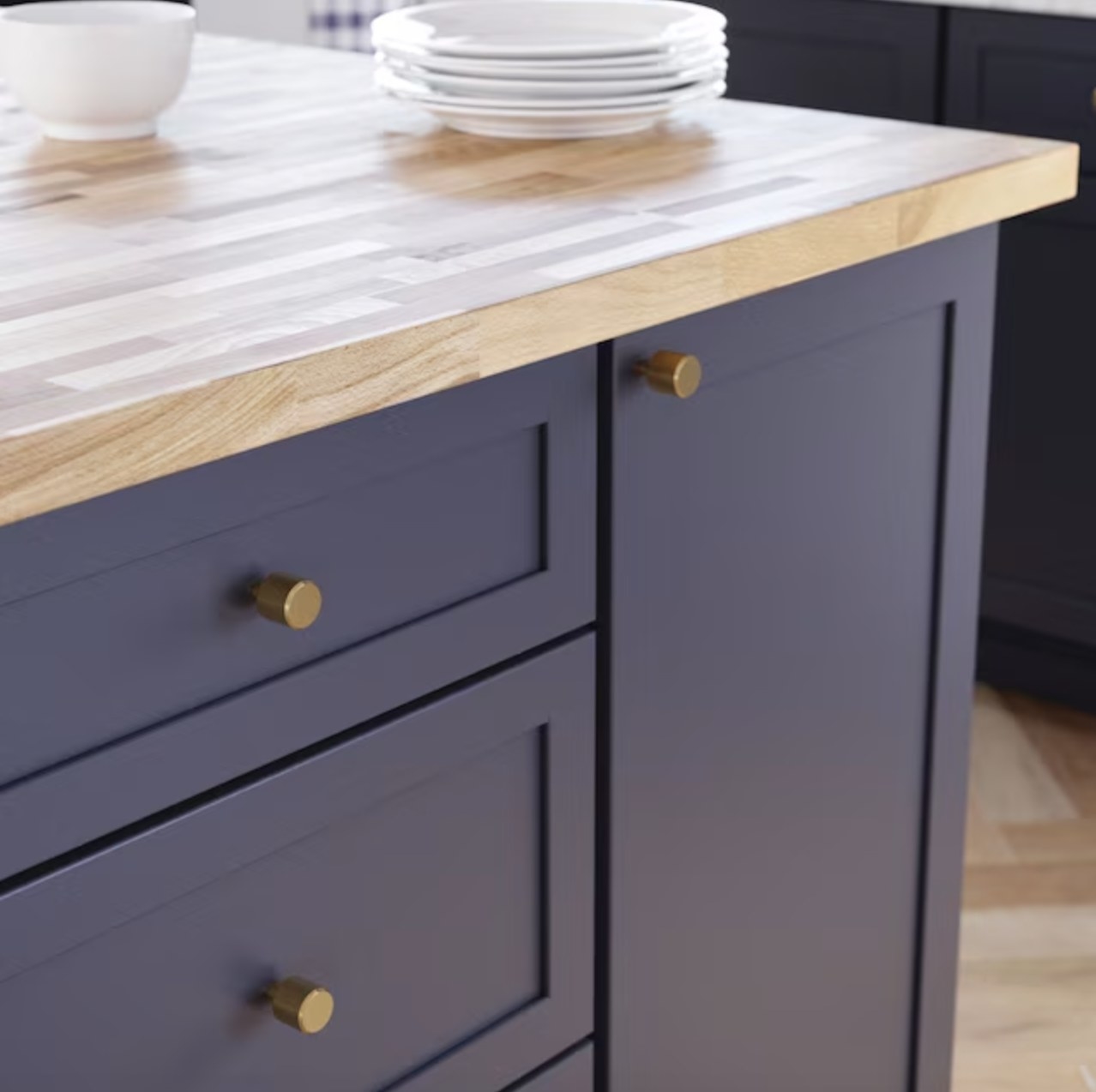 the gold round knobs on blue cabinets with a wooden countertop