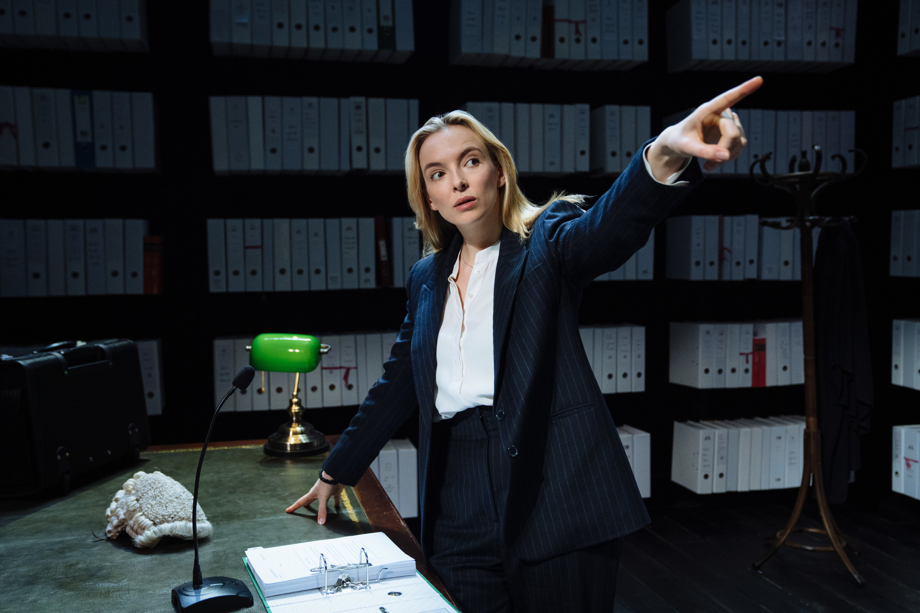Jodie as the lawyer pointing towards something as with a file open before her
