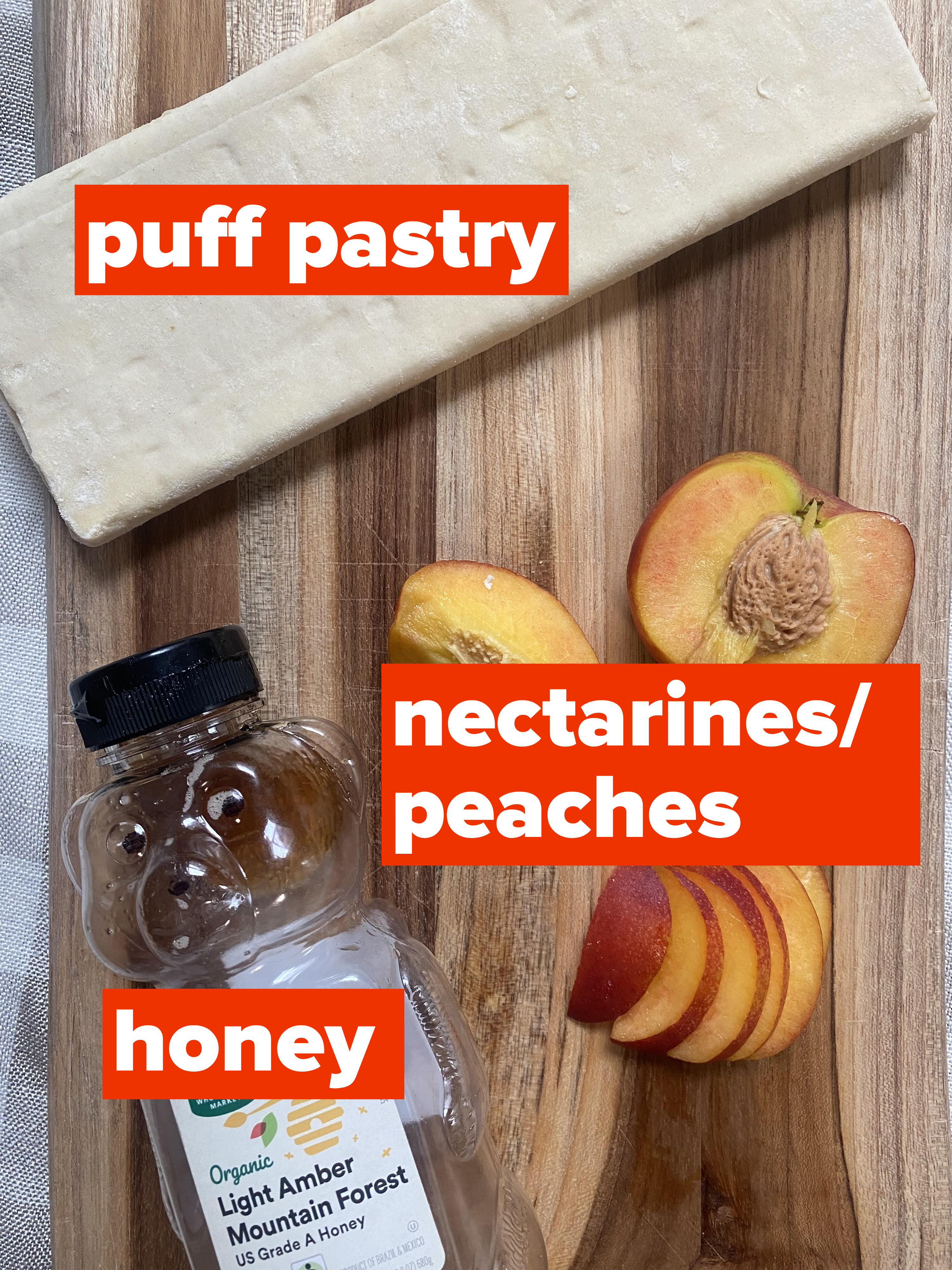 Puff pastry, peaches, and honey on a cutting board