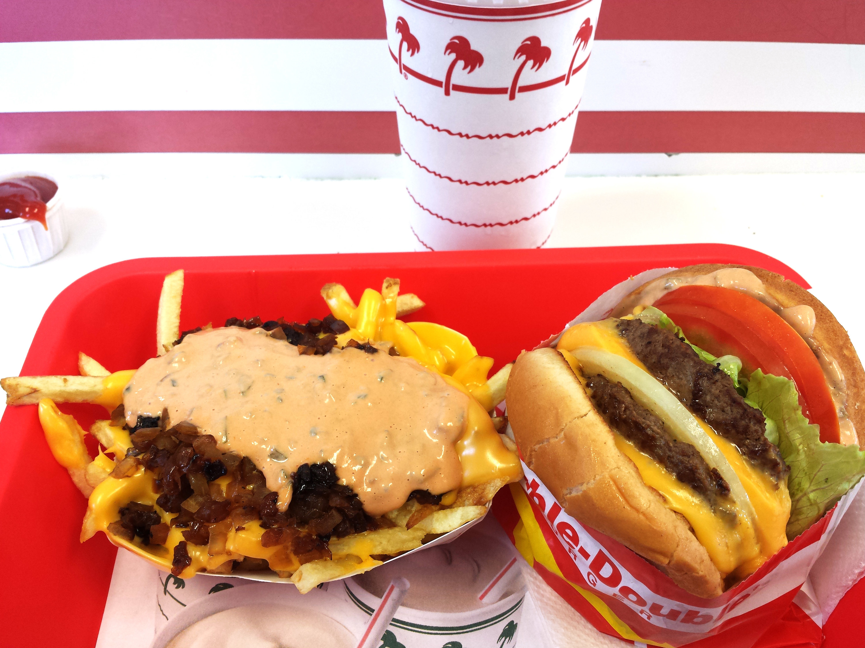 Animal Style fries and an In-N-Out burger with a soda