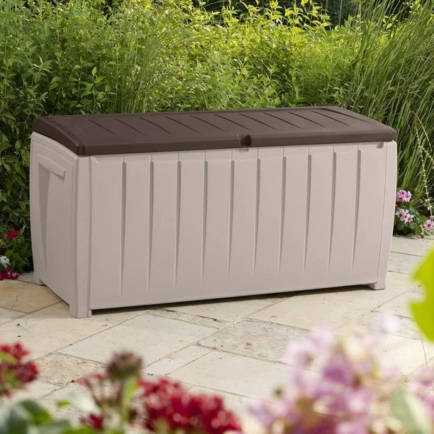 an outdoor deck box in a patio surrounded by flowers
