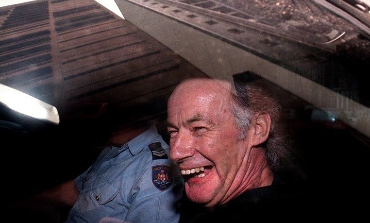 closeup of him smiling with a police officer next to him