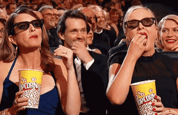 Tina Fey and Amy Poehler eating movie theater popcorn at the Emmy Awards