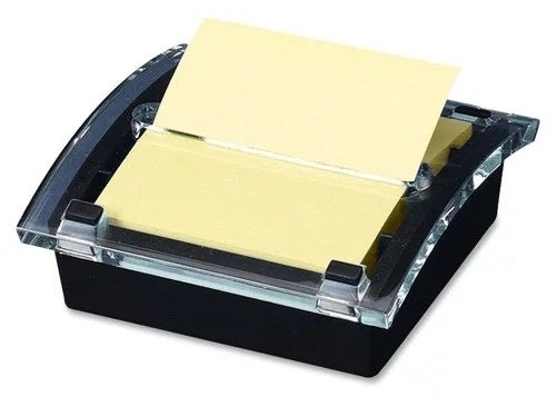 a black note dispenser holding yellow sticky notes