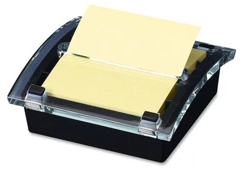 a black note dispenser holding a yellow sticky pad