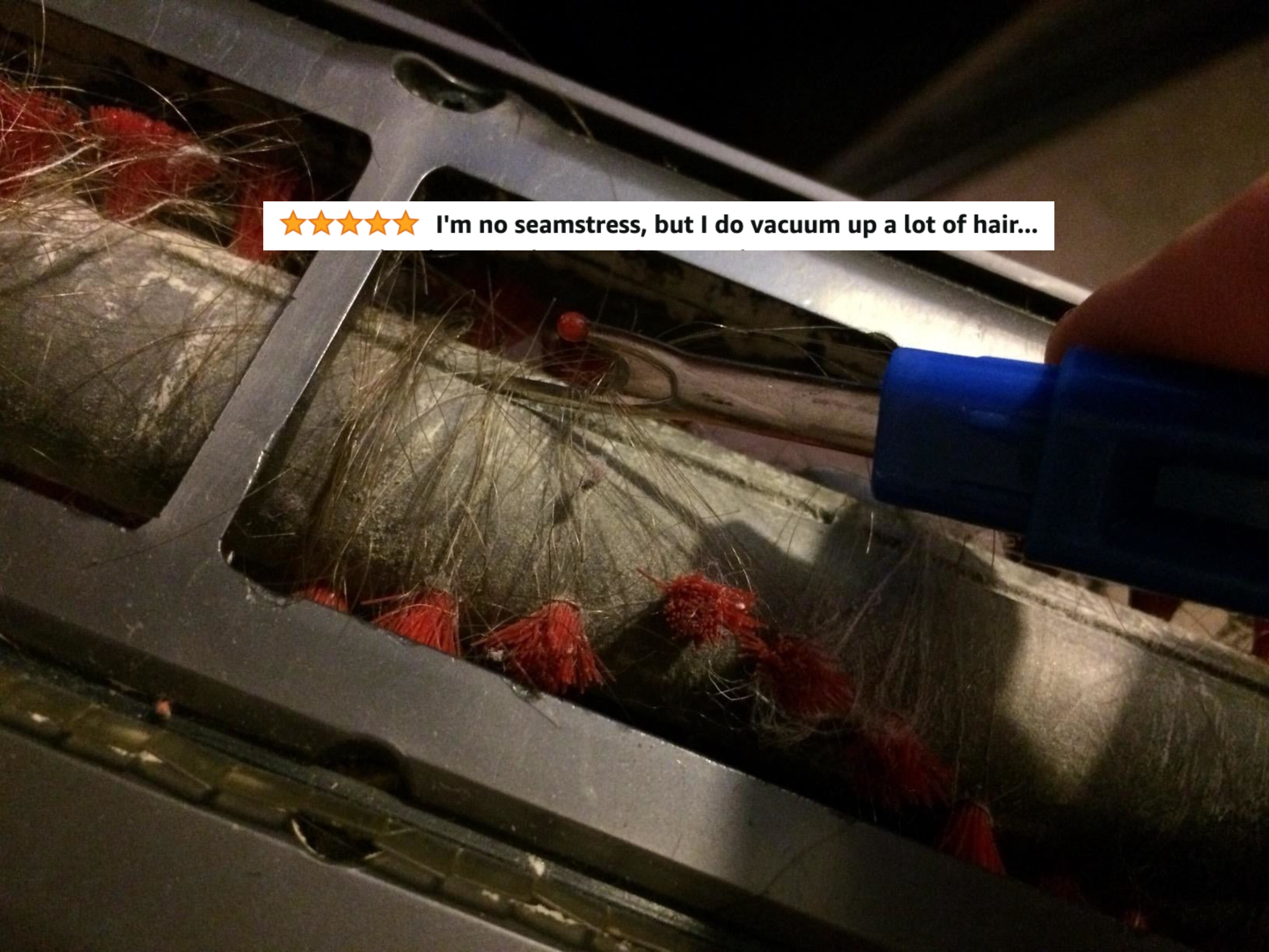 A reviewer using the seam ripper to cut through hair wrapped around their vacuum roller with five stars and text &quot;I&#x27;m no seamstress, but I do vacuum up a lot of hair&quot;