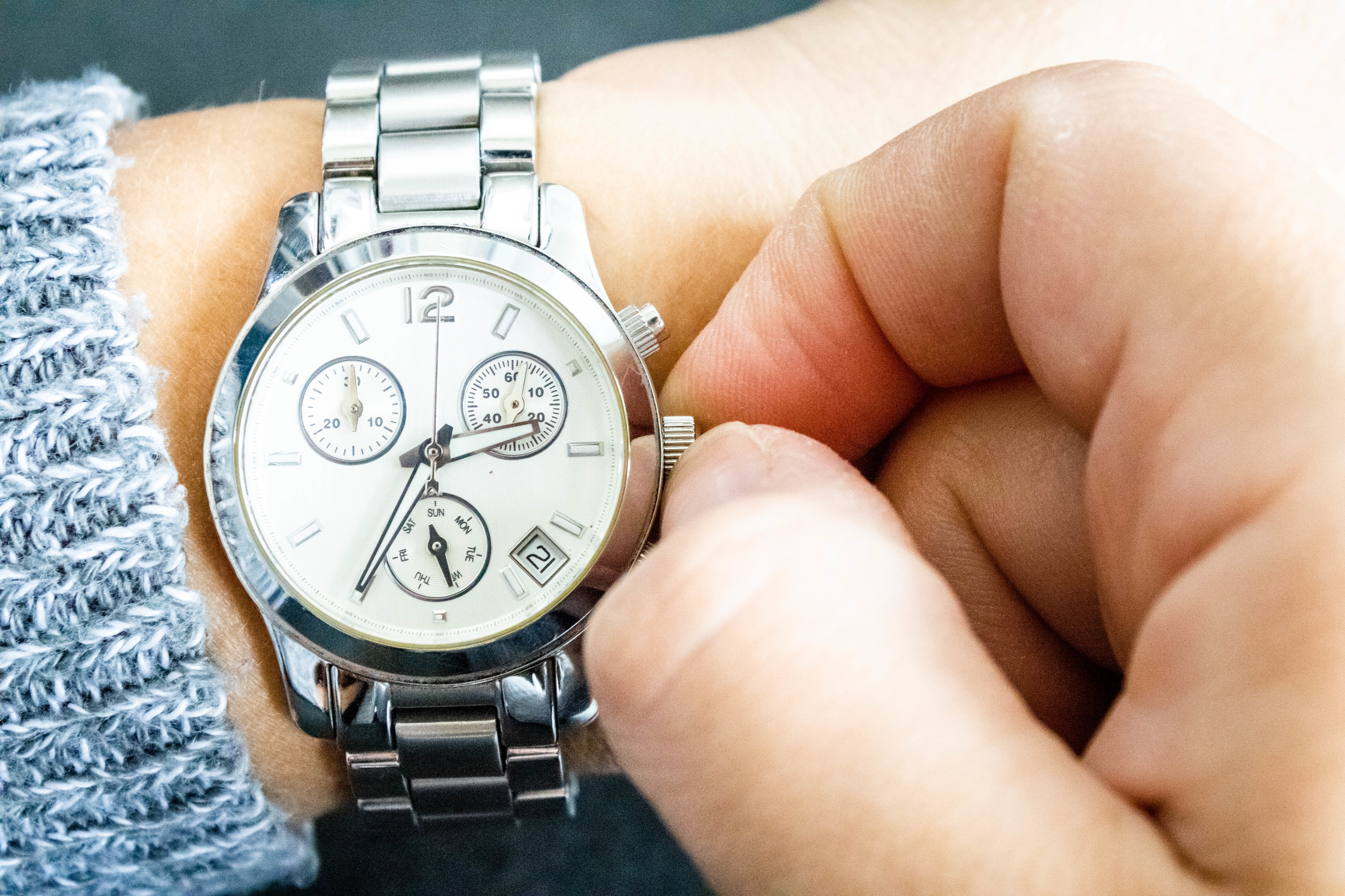person sets their wrist watch
