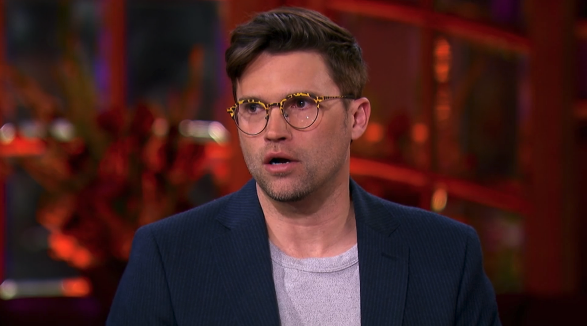 Tom wearing glasses and a blazer during the reunion