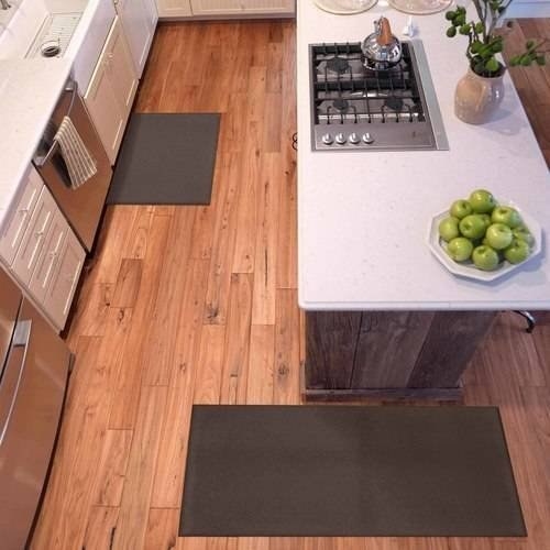 two brown mats by kitchen cabinets