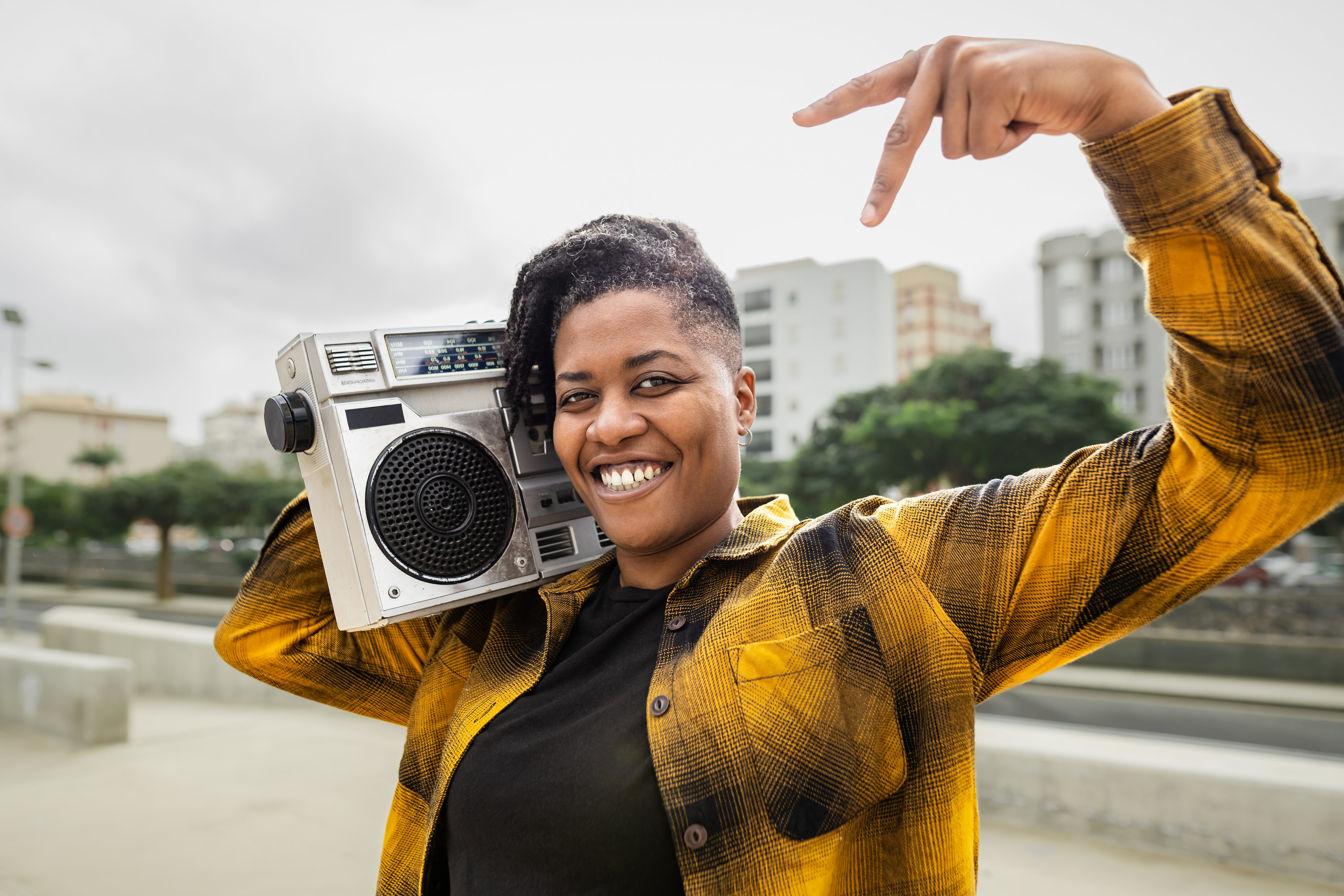 woman carries boombox on her shoulder